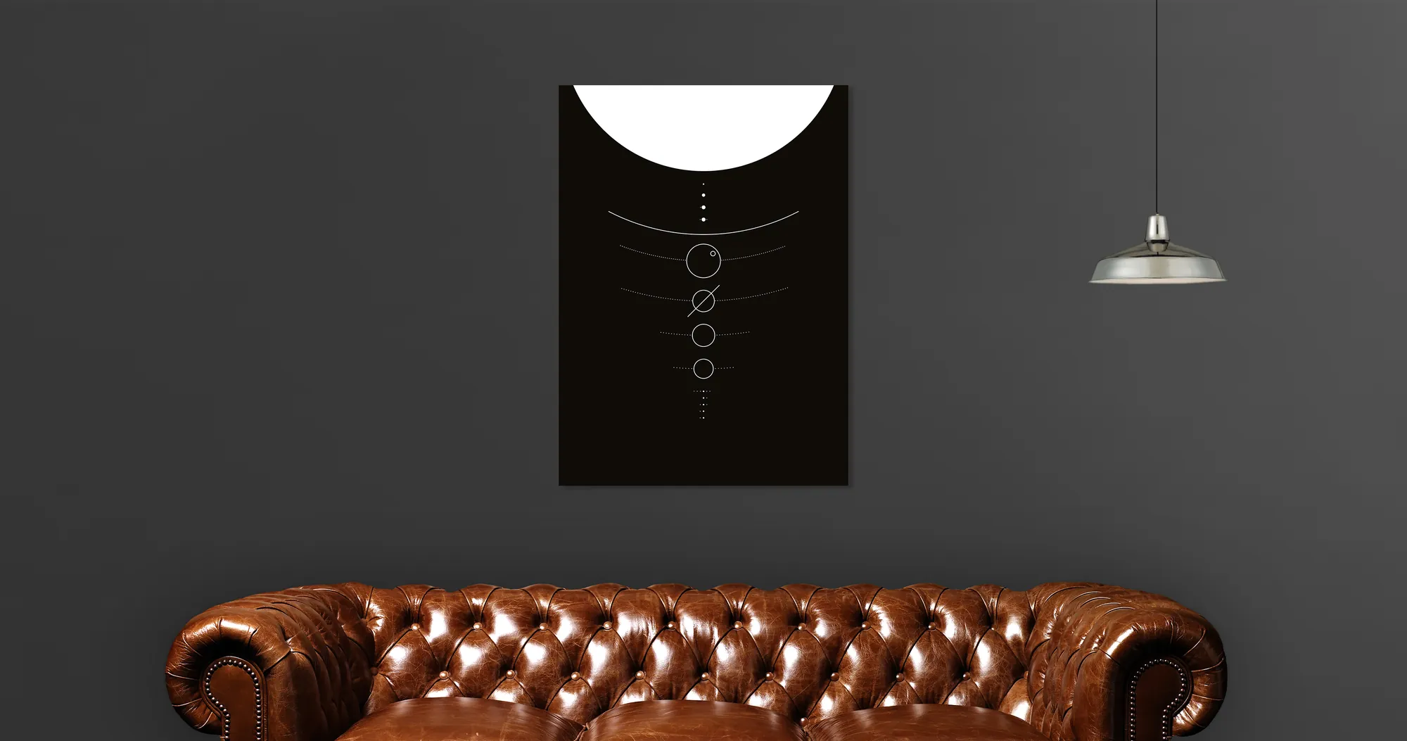 Solar system print hung above a brown leather chesterfield